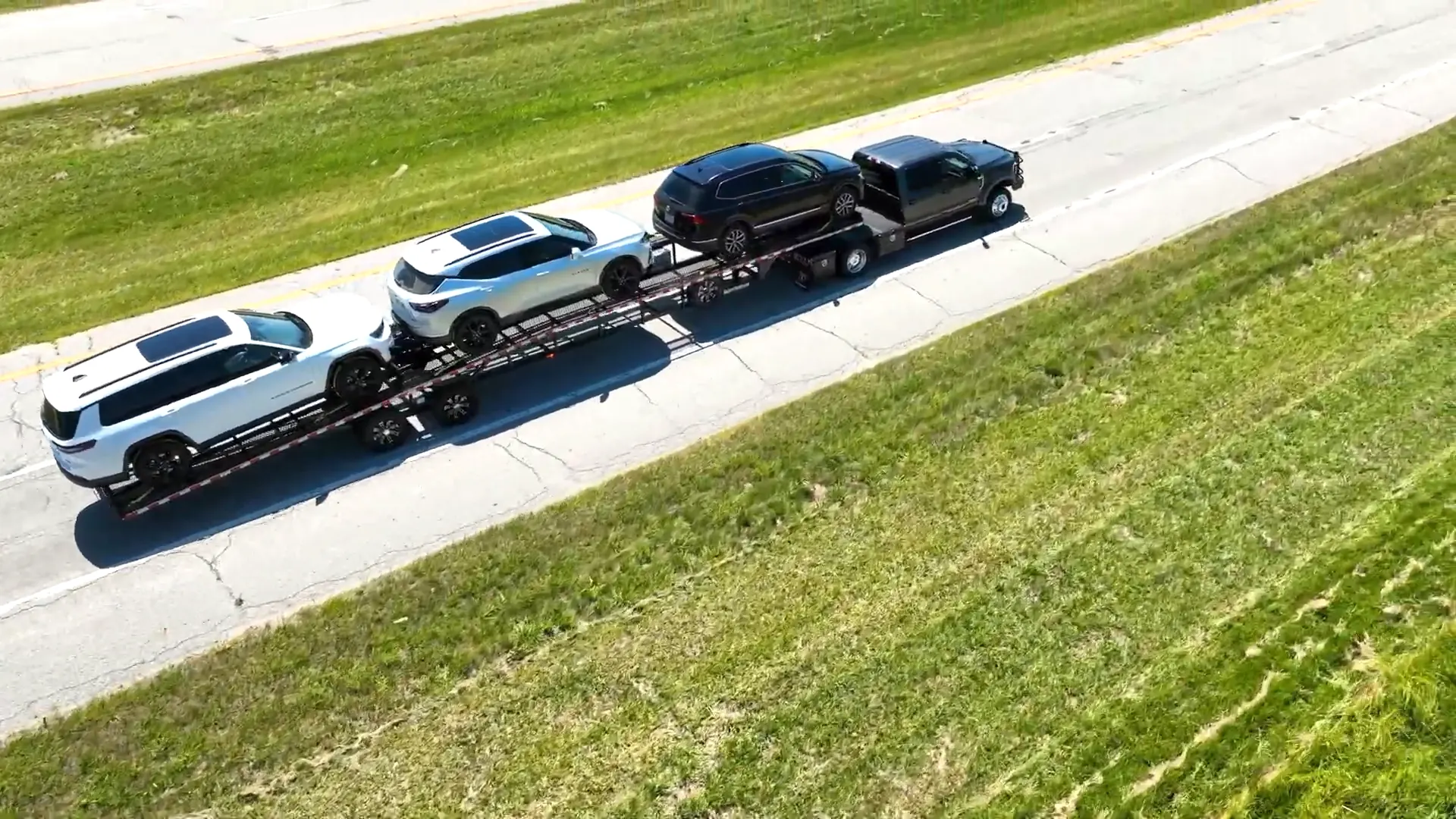 Drone view of a pickup pulling four cars on a Buckeye car hauler