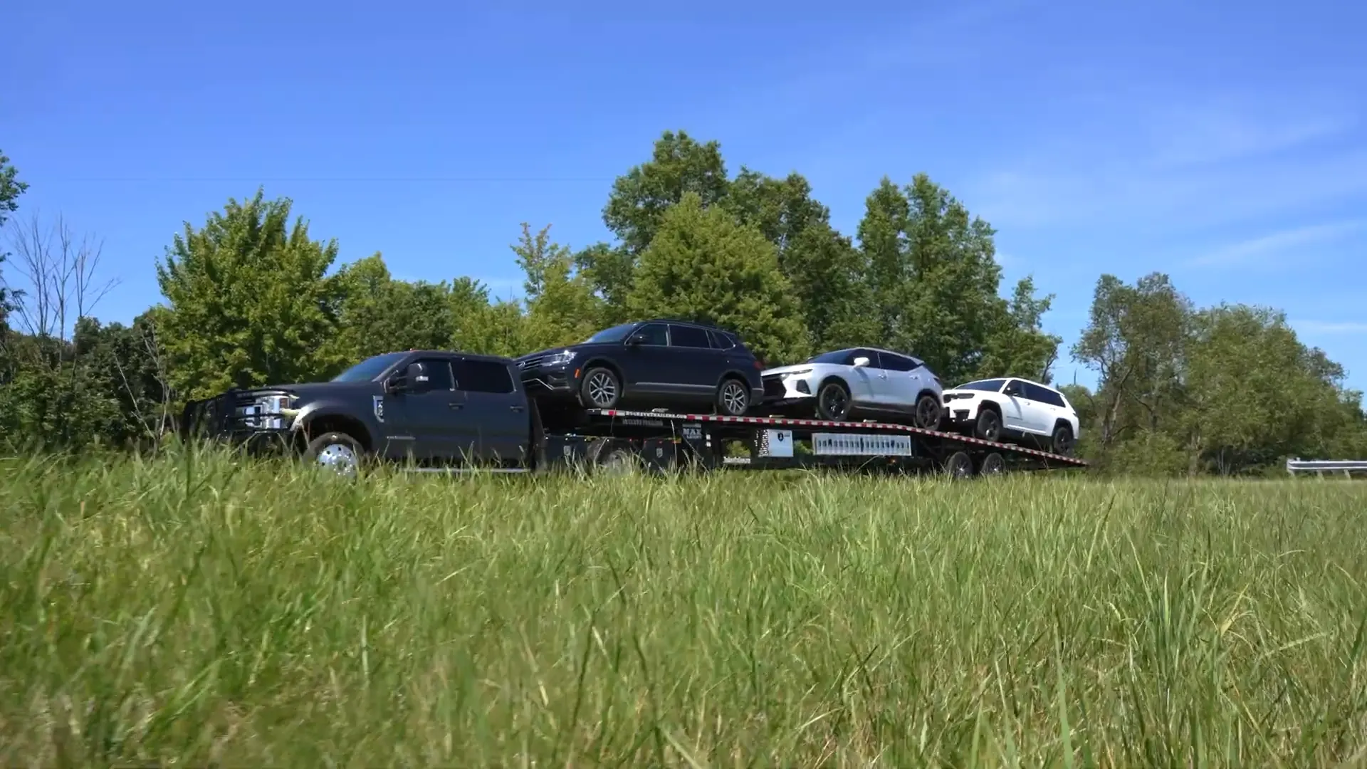 Pickup truck pulling four cars on a Buckeye trailer